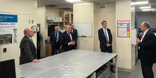 group of men in suits standing in an office lab space